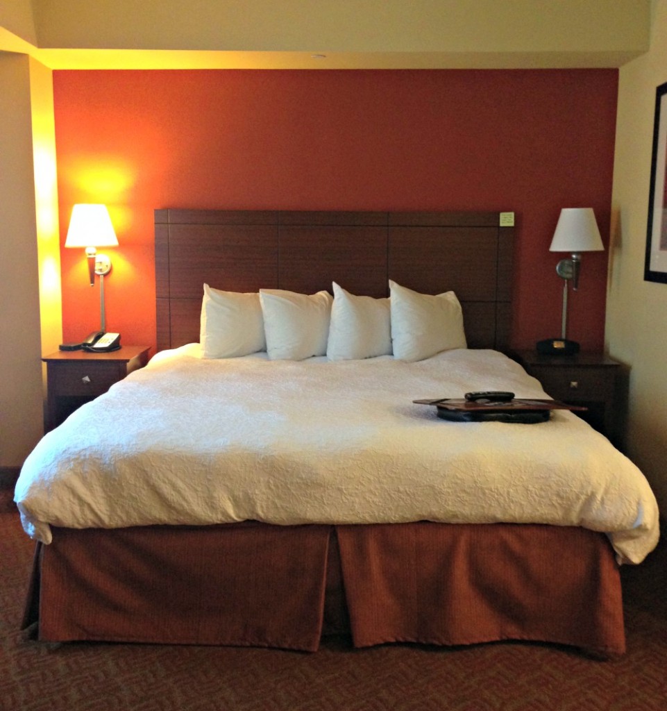 A cosy king sized bed at Hampton Inn & Suites